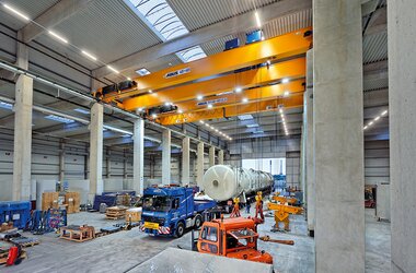 Double girder travelling crane in tandem control unloading the truck