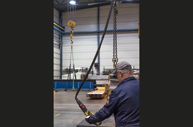 Employee operates chain hoist in Finnish company Konepaja Enne Oy