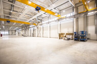 Mounted ABUS single girder travelling cranes with LED light lines in hall of Caljan company