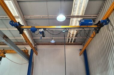 Suspended rail system with jacked-up crane for low headroom